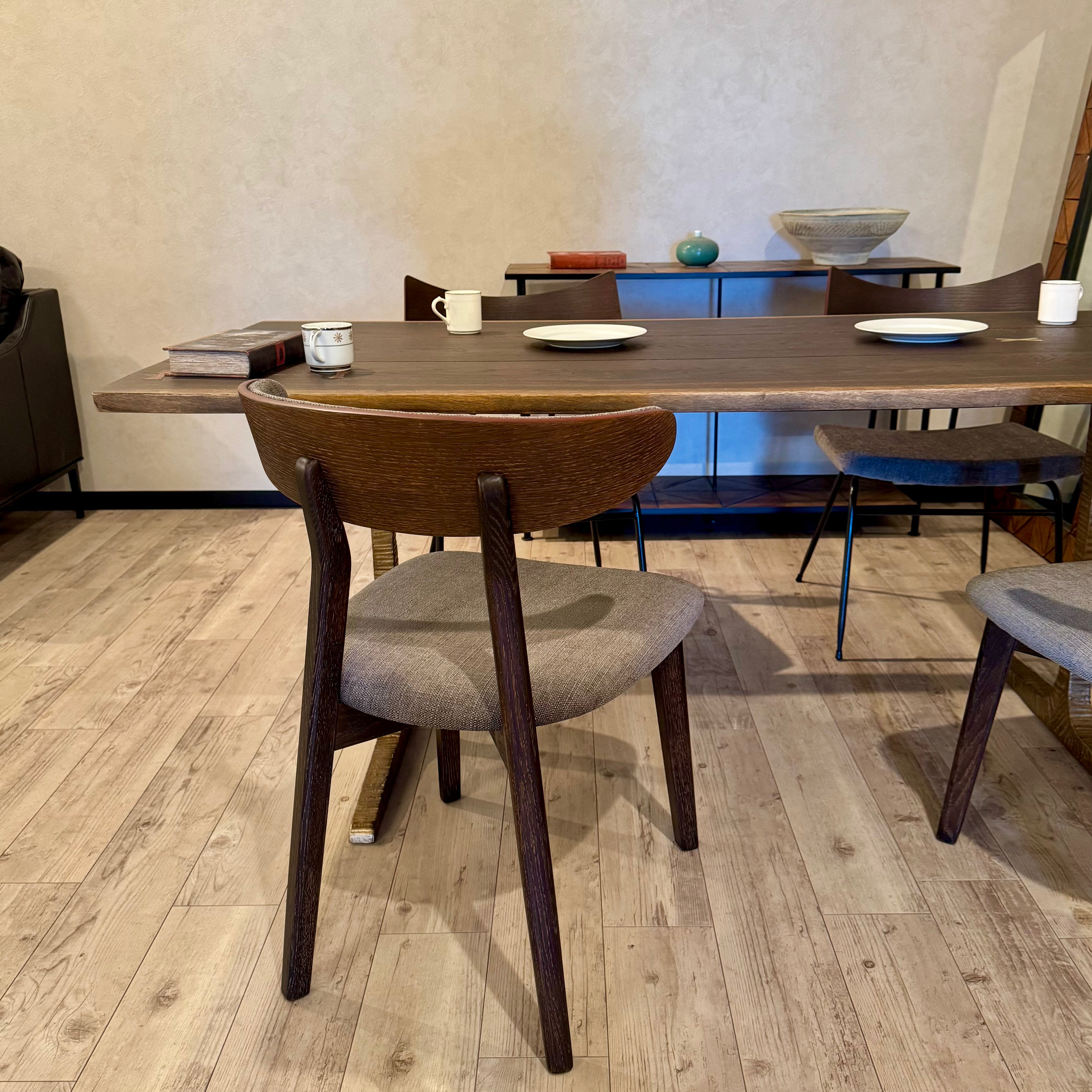 ダイニングで背面から見たBOMA CHAIRのオーク材背もたれと木製脚
