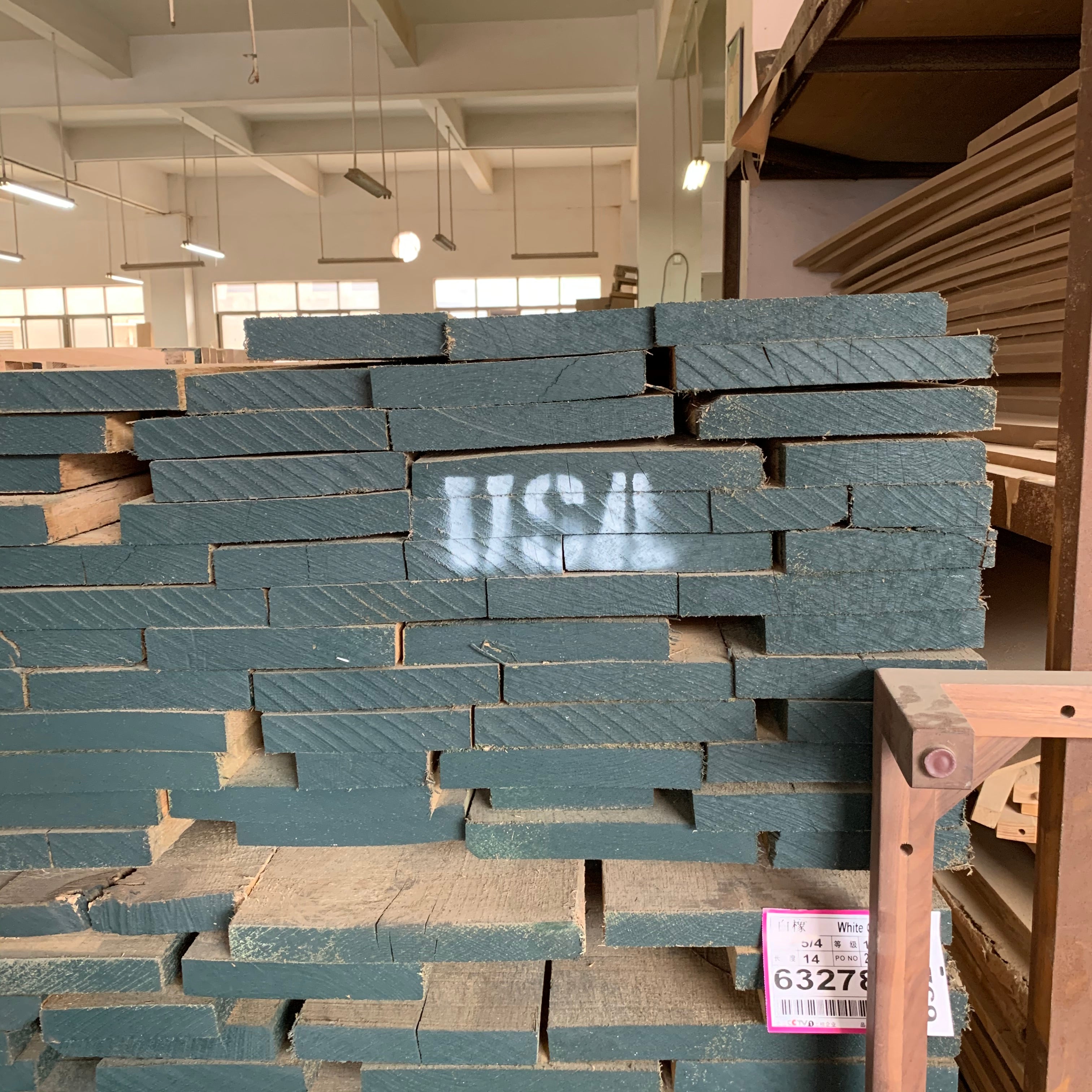 BONDI DINING TABLE 1600 NT に使用する無垢材の確認風景。天板になる前の素材を工場で確認している写真。